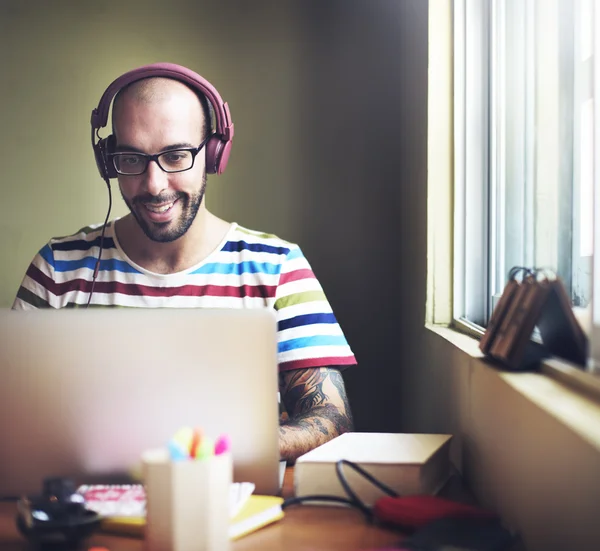 Homem com fones de ouvido trabalhando no computador portátil — Fotografia de Stock