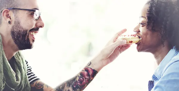 Мужчина кормит свою девушку пончиками — стоковое фото