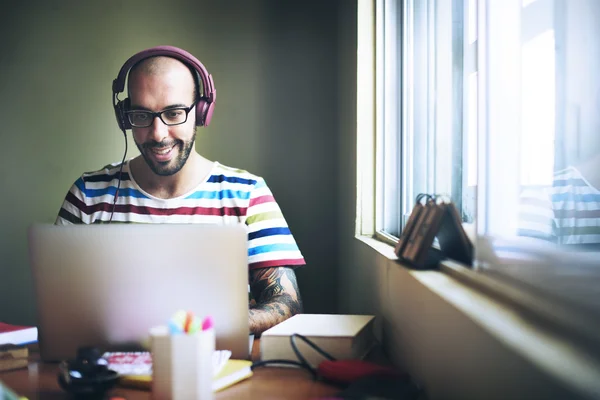 Homme avec écouteurs travaillant sur ordinateur portable — Photo