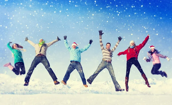 Freunde springen im Schnee — Stockfoto