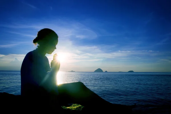 Young woman praying at sunset — Stock Photo, Image