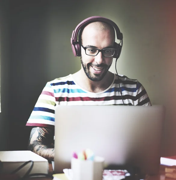 Hombre con auriculares que trabajan en el ordenador portátil —  Fotos de Stock