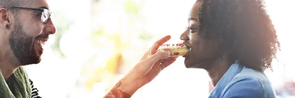 Homem alimentando sua namorada com donut — Fotografia de Stock