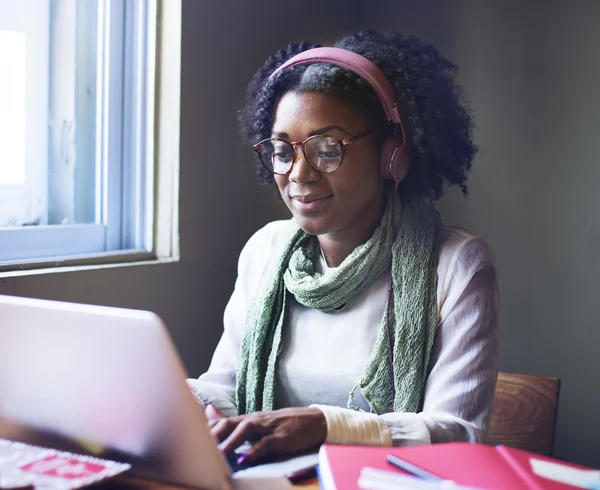 Donna d'affari con cuffie che lavora su laptop — Foto Stock