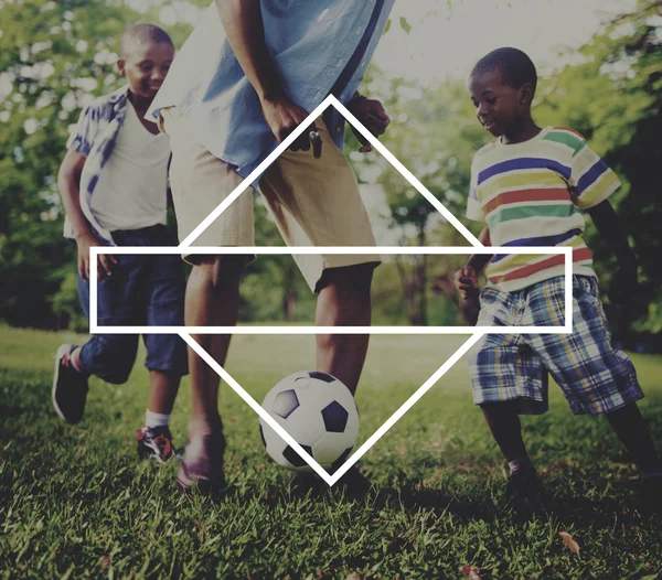 Πατέρας και Υιοί, παίζοντας ποδόσφαιρο στο πάρκο — Φωτογραφία Αρχείου