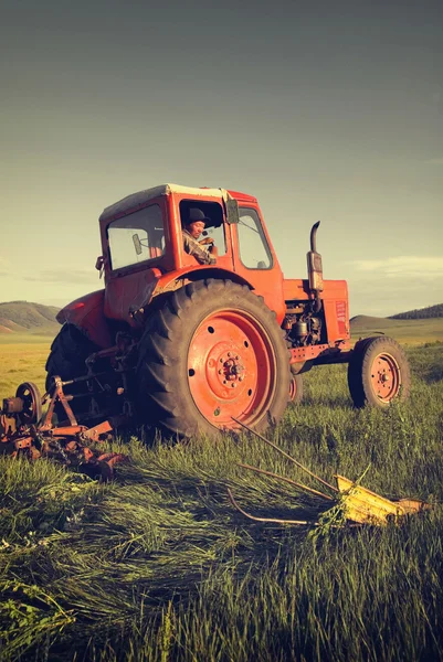 Mongolian farmer driving tractor — Stock Photo, Image