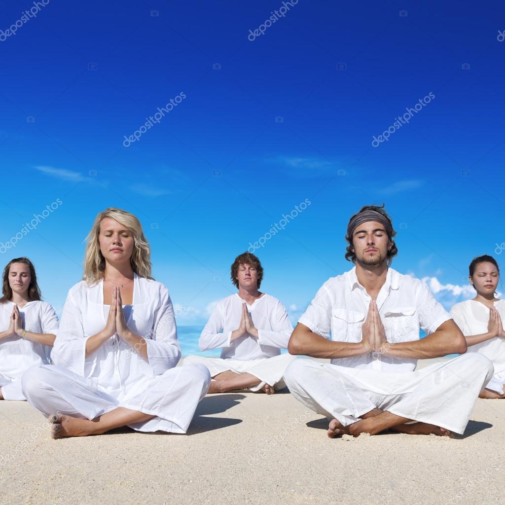 People performing yoga on the beach Concept