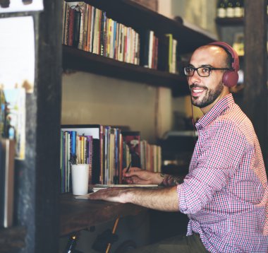 kulaklık dizüstü bilgisayar üzerinde çalışan adamla