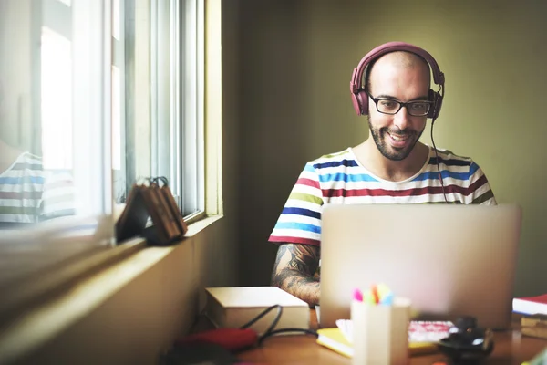 Homme avec écouteurs travaillant sur ordinateur portable — Photo