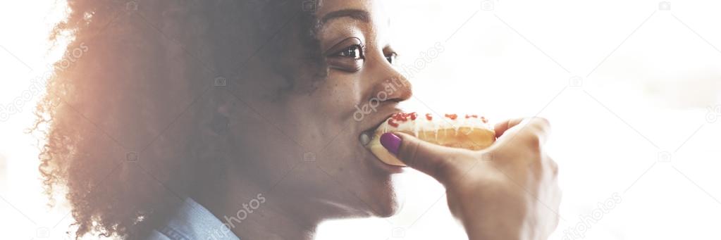 woman eating tasty doughnut