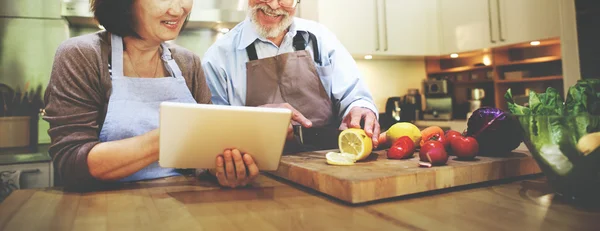 couple cooking and using laptop