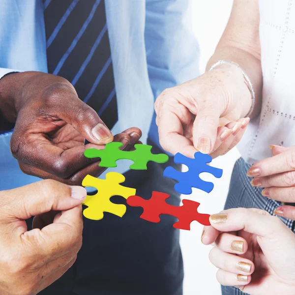 Business people hold puzzles — Stock Photo, Image