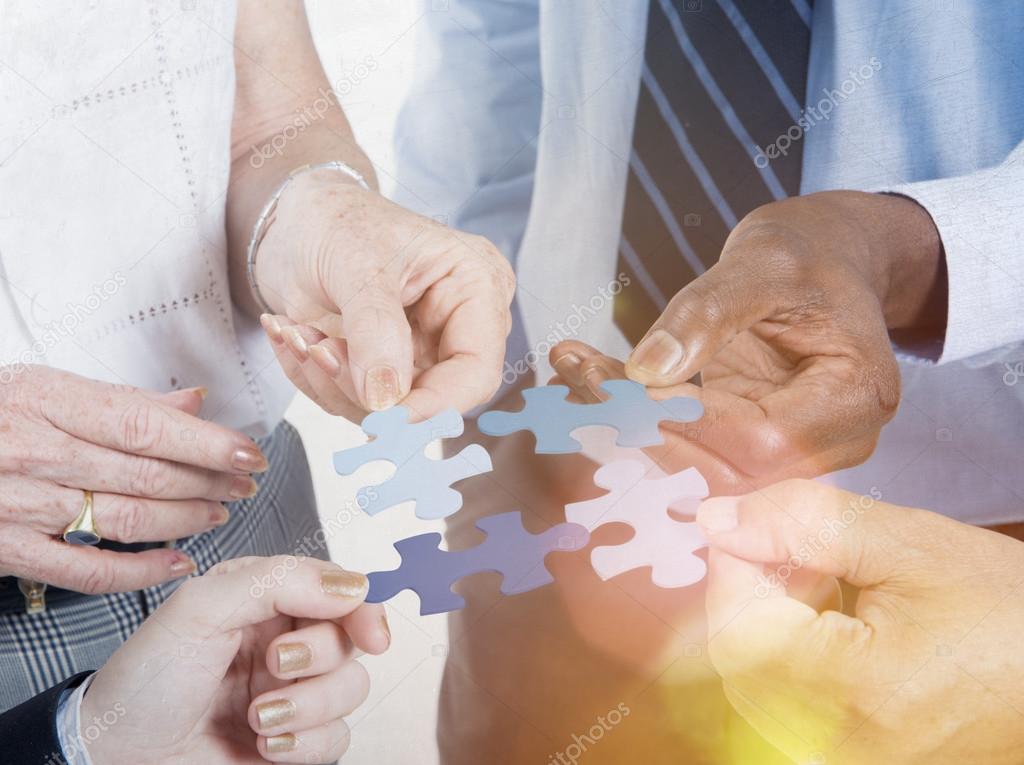 Business people hold puzzles