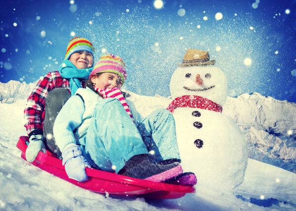 children riding on snow sledge