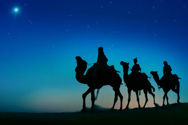 Los hombres montando camellos a través del desierto — Foto de Stock