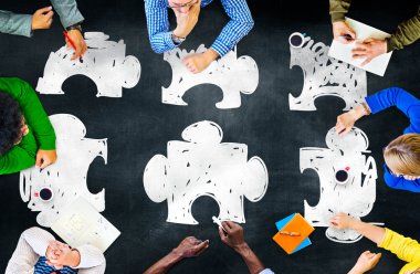 Jigsaw üzerinde işaret eden iş adamları bulmaca