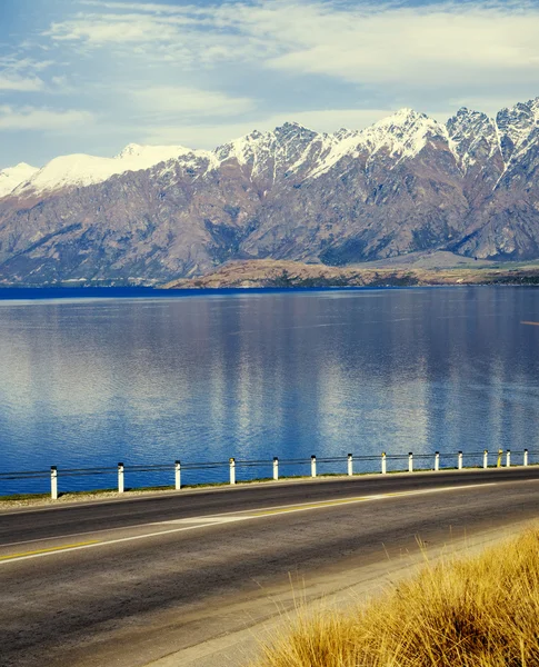 Route avec lac et chaîne de montagnes — Photo