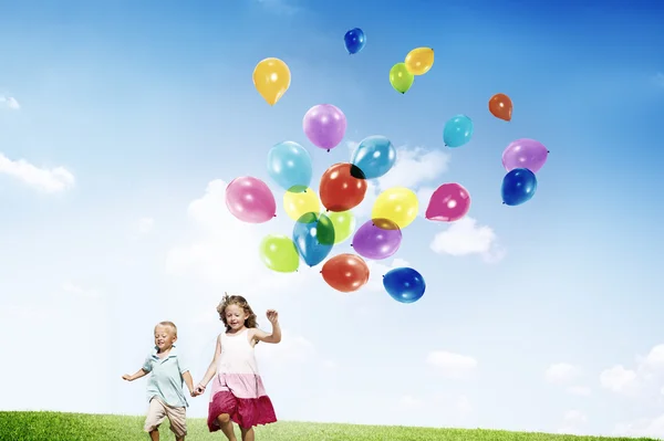 Niña y Niño sosteniendo globos — Foto de Stock