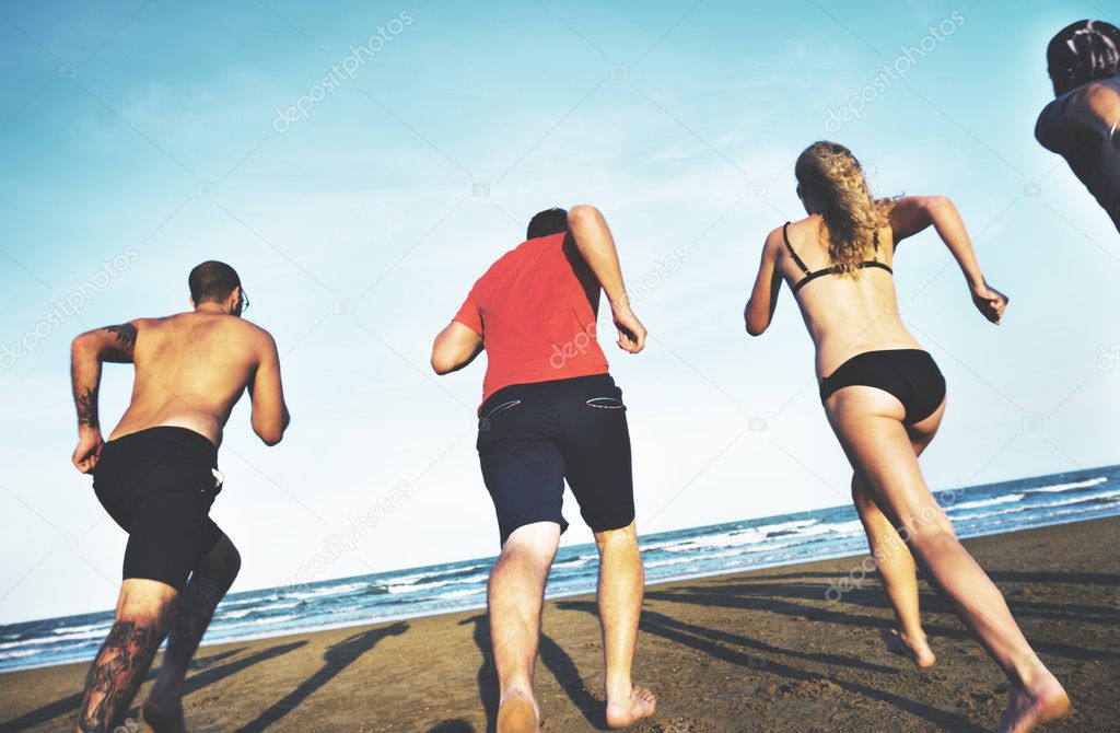 friends running on sand to sea