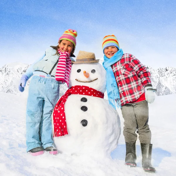 Gyermekek birtoklás móka-val hóember — Stock Fotó