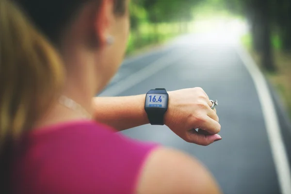 Sportswoman with digital device at outdoors