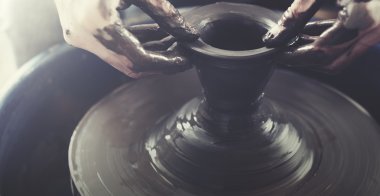 Kişi çömlek çamurla oluşturur.