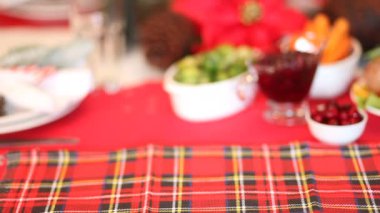 Şükran Günü ya da Noel yemeği için servis edilen masa. Kadın eli masaya içi doldurulmuş hindi dolu bir tabak koydu. Geleneksel kutlama tatili