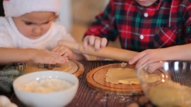 Noel Baba şapkalı çocuklar evde Noel kurabiyesi pişiriyor..