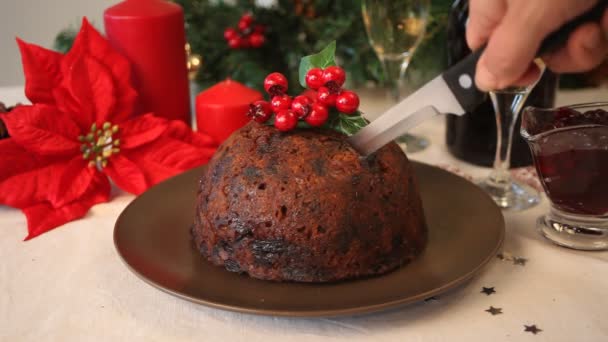 Vrouw Hand Gesneden Een Kerst Pudding Met Hulst Top — Stockvideo