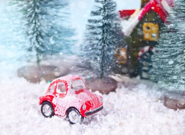 Çam ağaçları ve oyuncak kırmızı arabalı Noel kompozisyonu.