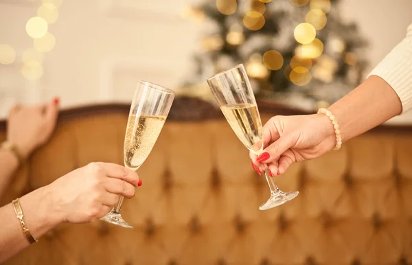 Vrouwen handen die de glazen champagne vasthouden en een toast uitbrengen. Kerstfeest concept. — Stockfoto