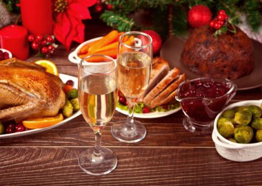 Şükran Günü ya da Noel yemeği için servis edilen masa. İki kadeh şarap ya da şampanya. Doldurulmuş hindi, puding ve jambon. Geleneksel kutlama tatili. Üst görünüm.