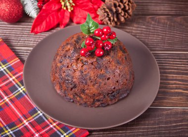 Geleneksel Noel pudingi, ahşap arka planda Holly var.