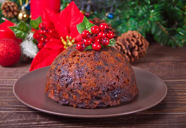 Traditional Christmas pudding with holly on top on the wooden background — Stock Photo, Image