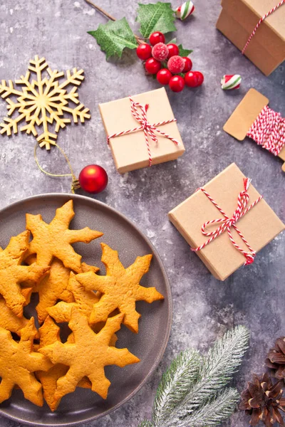 Weihnachtsdekoration mit Zapfen, Plätzchen, Geschenkschachteln, roten Kerzen, Bonbons. Ansicht von oben. — Stockfoto