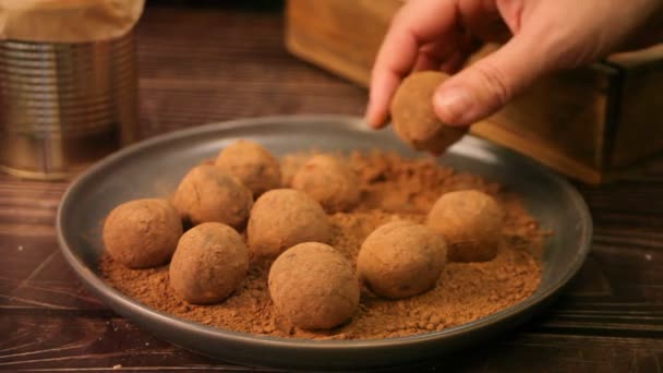 Mujer mano hacer un chocolate casero bolas trufas y rollos en polvo de cacao. — Vídeos de Stock