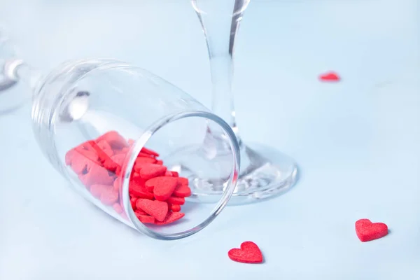 Dois copos de champanhe com doces em forma de coração vermelho. Conceito do Dia dos Namorados. — Fotografia de Stock
