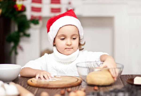 Смішна дівчина в Санта-капці випікання різдвяного печива вдома — стокове фото