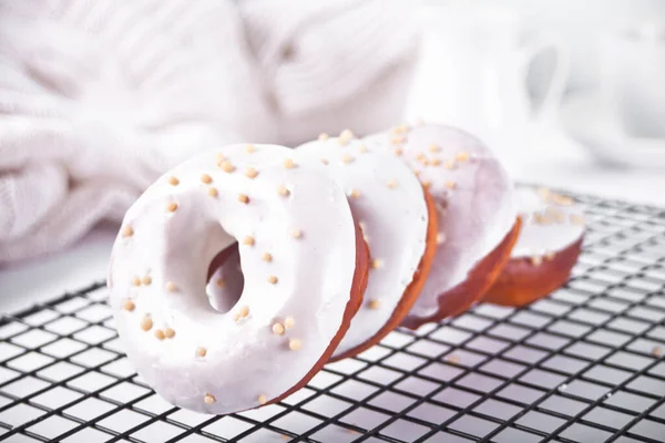 Doughnut on the baking rack glazed with white chocolate cream or icing — Stock Photo, Image