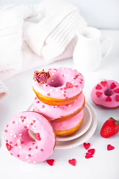 Une pile de beignets roses sur l'assiette. Concept Saint-Valentin. — Photo