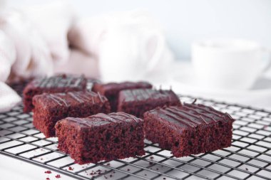 Çikolatalı kek ve arka rafta bir fincan çay.