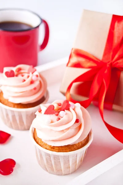 Valentine cupcake creme queijo cobertura decorada com doces do coração, caneca de café e caixa de presente no fundo. — Fotografia de Stock