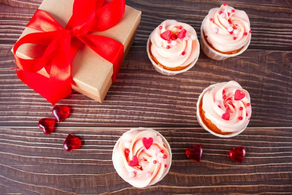 Valentines cupcakes cream cheese frosting decorated with heart candy on the wooden background. — Stock Photo, Image