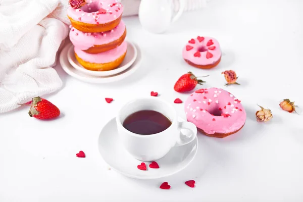 Cup of coffee and pink doughnuts on the white background. Valentines Day concept. — Stock Photo, Image