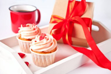 Sevgililer Günü kekleri krem peynirli krem peynir, kalp şekeriyle süslenmiş, bir kupa kahve ve hediye paketi. Sevgililer Günü konsepti.