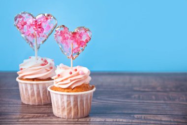 Sevgililer Günü çörekleri krem peynirli krem şantili, kalp şeklinde lolipopla süslenmiş. Boşluğu kopyala.