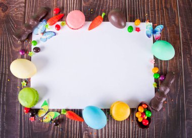 Paskalya çerçevesi ve temiz beyaz çarşaf yumurta, havuç, çikolatalı tavşan, şekerler, kurabiyeler.