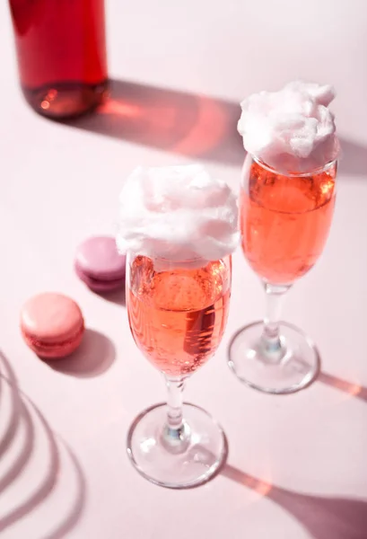 Glasögon med söt bomull godis rosa cocktail och flaska på bakgrunden — Stockfoto