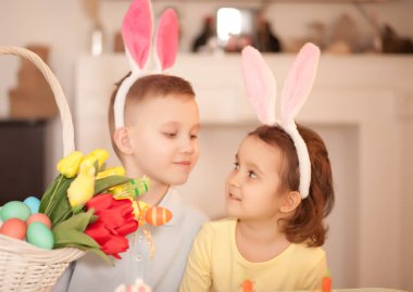 İlkbaharda evde tavşan kulağı takan komik kız ve erkek çocuk.