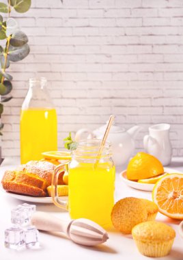 Bir kavanoz taze limonata. Arka planda dilimlenmiş limon.